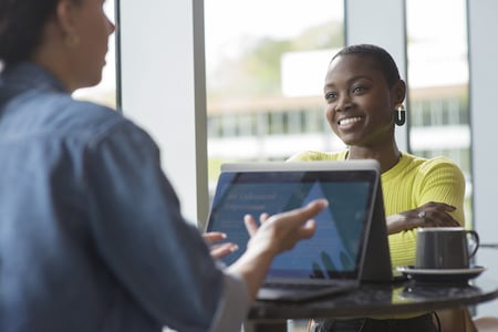 Photo of person with tablet explaining idempotent API process to another person. 